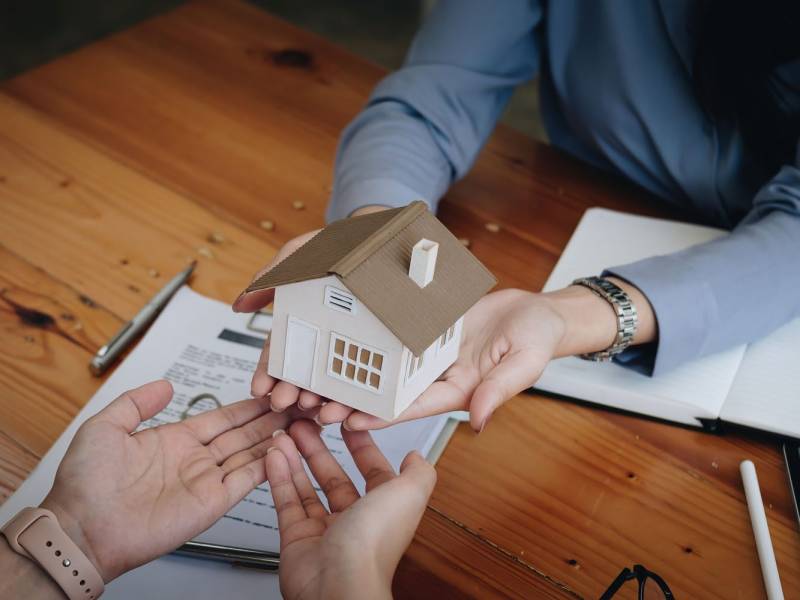 Real estate agent or sales manager offer home sale and explained the terms of signing the house purchase contract and free home insurance. Mortgage property insurance dream moving home and real estate concept